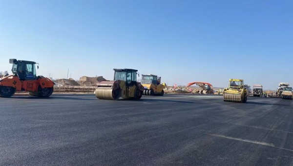 近日，在西部市政建設(shè)集團(tuán)蘭州新區(qū)城市礦產(chǎn)與表面處理產(chǎn)業(yè)園區(qū)（二期）周邊基礎(chǔ)設(shè)施項(xiàng)目—園區(qū)西路南延段（緯五十路至緯二十八路）項(xiàng)目現(xiàn)場(chǎng)，隨著一輛輛運(yùn)料車平穩(wěn)駛?cè)?，攤鋪機(jī)將滾燙的瀝青混合料均勻鋪開，標(biāo)志著項(xiàng)